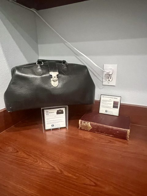 Vintage physician's bag and medical book on display at Meadow Primary Care